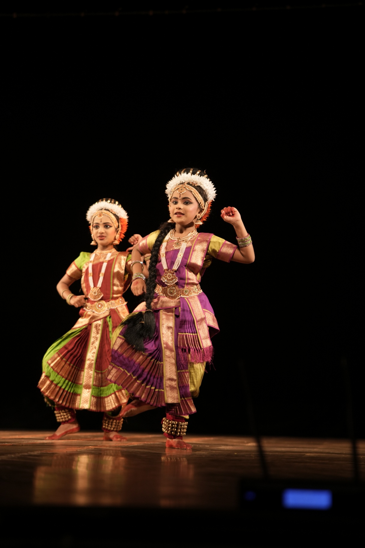 Two young dancers performing with energy on stage
